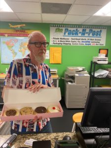 pack and post employee holding box of crumbl cookies