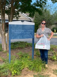 acclaim employee holding doughnuts in front of pathways center