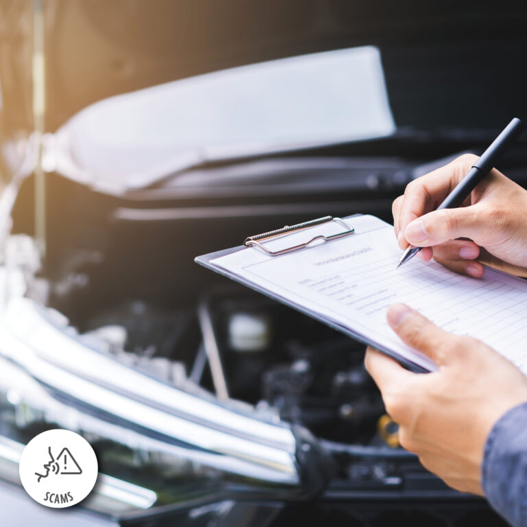 closeup of auto mechanic's hands while they write on a clipboard