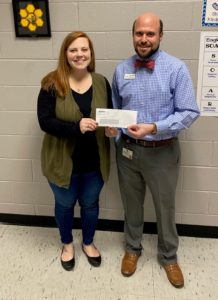 acclaim employee and school representative with donation check