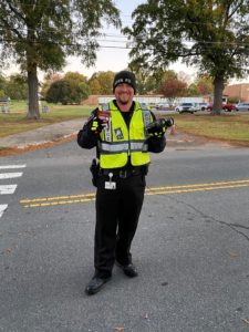 police officer directing traffic, posing with gift card and drink