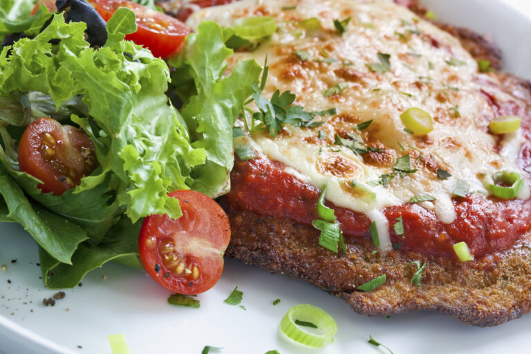 dish with chicken parmesan and garnishes