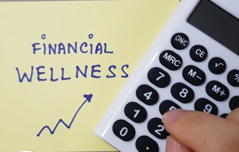 calculator and post-it note that reads 'financial wellness'