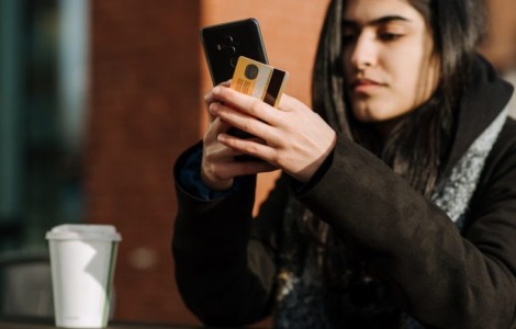 close up image of woman on phone drinking coffee