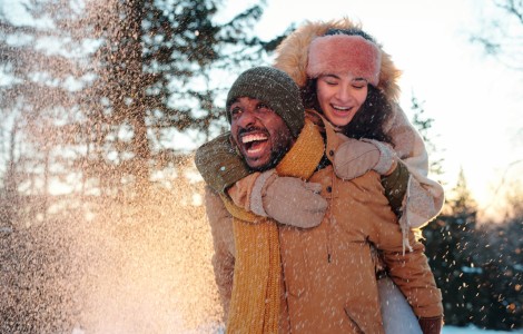 couple in winterwear playing in snow