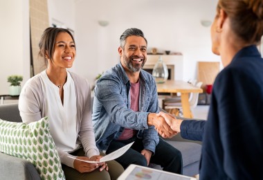 couple shaking hands with consultant