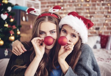 two women with holiday ornaments as reindeer noses