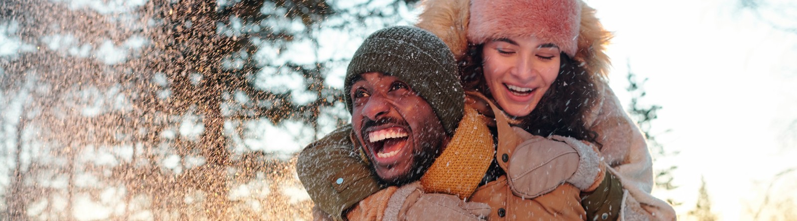 couple in winterwear playing in the snow