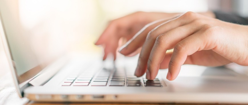 close up of hands typing on a laptop