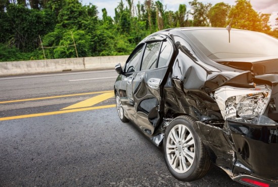 car on side of the road badly damaged by an accident